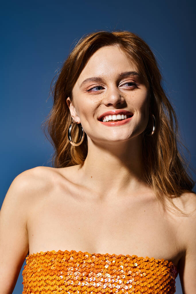 Αυτοπεποίθηση χαμογελαστή γυναίκα κοιτάζοντας μακριά με φυσικό γυμνό ροδακινί μακιγιάζ, σε μπλε φόντο - Φωτογραφία, εικόνα
