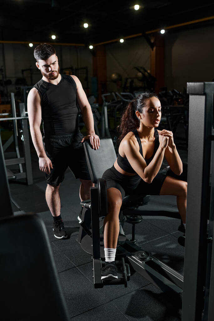 Ein Personal Trainer arbeitet mit einer brünetten Sportlerin in einem Fitnessstudio und konzentriert sich auf Kraft und Konditionierung. - Foto, Bild
