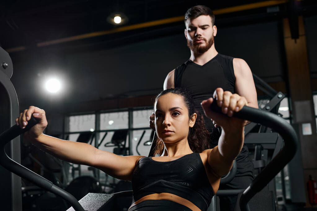 Mužský trenér motivuje brunetku sportovkyni během cvičení v tělocvičně. - Fotografie, Obrázek