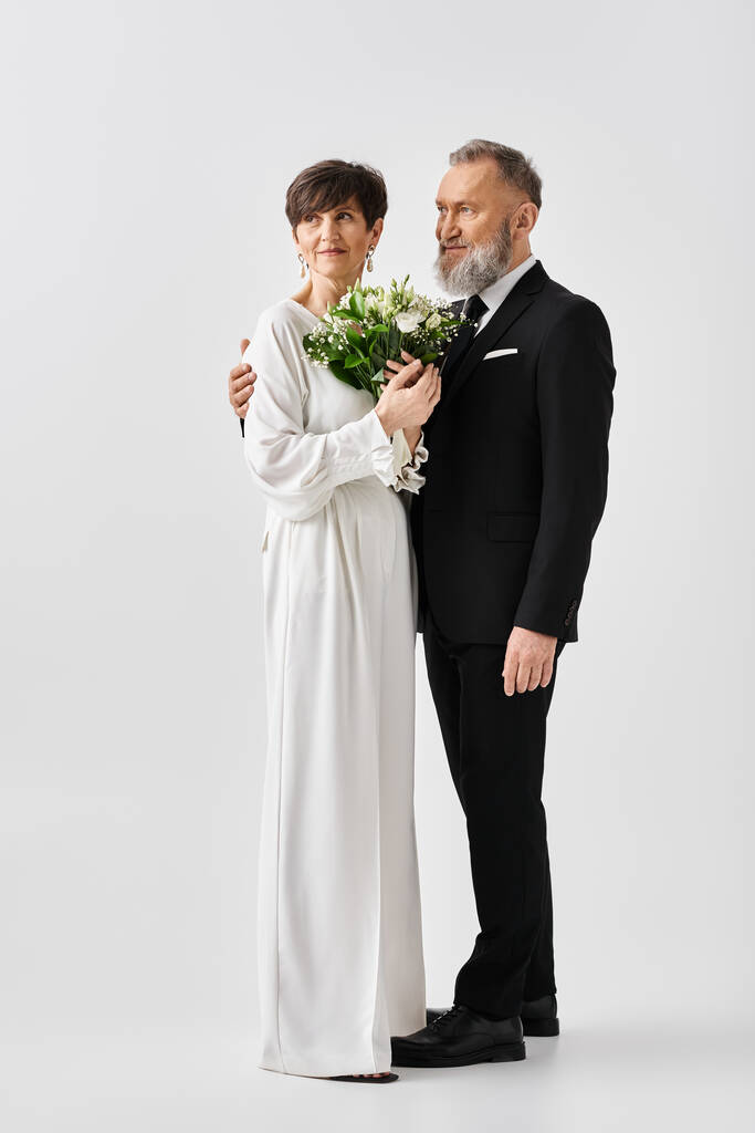 Ein Brautpaar mittleren Alters in weißem Hochzeitskleid, das einen Blumenstrauß umklammert und Freude und Liebe ausstrahlt. - Foto, Bild