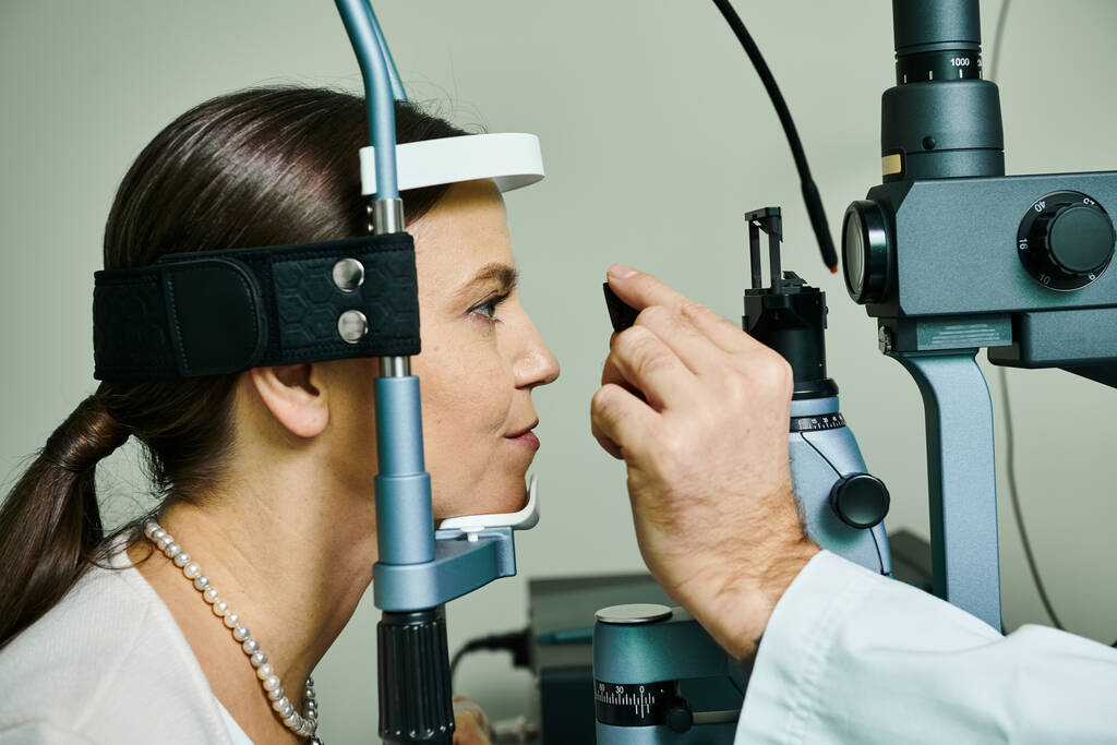 Kobieta poddana badaniu wzroku przez mężczyznę w gabinecie lekarskim. - Zdjęcie, obraz