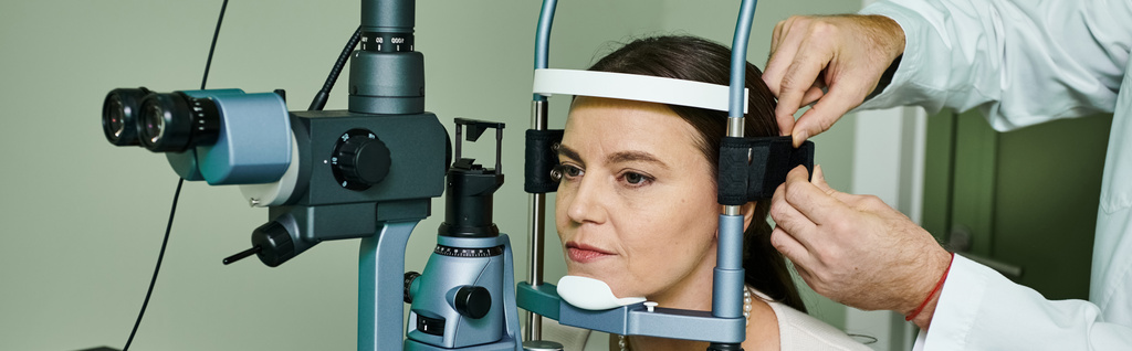 Eine Frau erhält eine Augenuntersuchung von einem Arzt in einem medizinischen Umfeld. - Foto, Bild