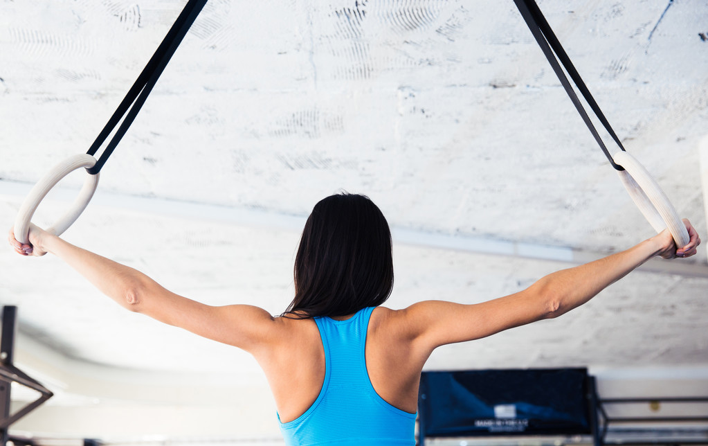 Rückseite Porträt einer Frau, die an gimnastischen Ringen trainiert - Foto, Bild