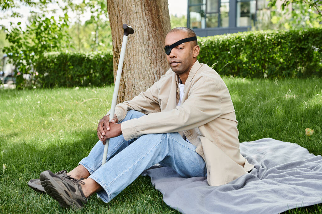 Um homem afro-americano com síndrome da miastenia gravis relaxando em um cobertor - Foto, Imagem