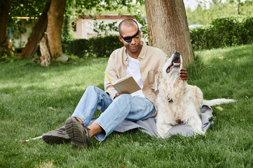 Un hombre afroamericano discapacitado con síndrome de miastenia gravis sentado pacíficamente en la hierba junto a su fiel perro labrador. - Foto, imagen