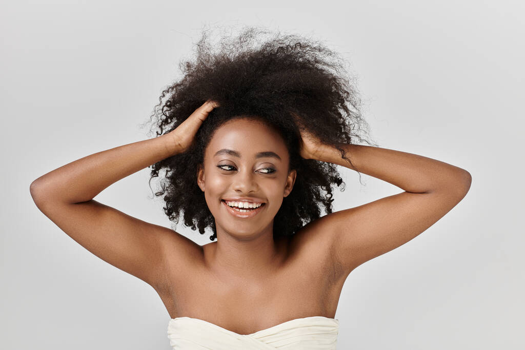 Afroameričanka s kudrnatými vlasy, ztělesňující eleganci a půvab ve studiu. - Fotografie, Obrázek