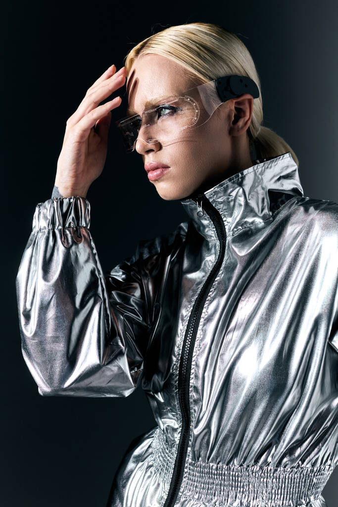 приваблива блондинка з науковими окулярами в футуристичному вбранні, дивлячись на темно-сірий фон - Фото, зображення