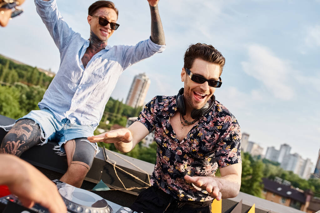 Canlı şehir kıyafetleri içinde neşeli güzel insanlar çatıda DJ 'lik yapmak için güneş gözlüklü partiler veriyorlar. - Fotoğraf, Görsel