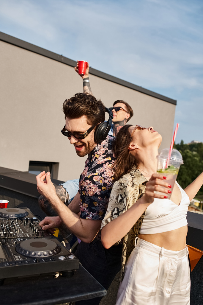 buoni amici gioiosi cercando in abiti urbani festivi che ballano al DJ set alla festa sul tetto insieme - Foto, immagini