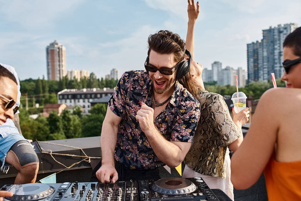 Moda güneş gözlüklü çok kültürlü neşeli arkadaşlar çatıdaki partide DJ 'lik yaparak eğleniyorlar. - Fotoğraf, Görsel