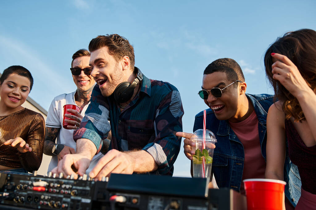 hommes et femmes multiraciaux joyeux dansant à la fête sur le toit avec DJ et boire des cocktails - Photo, image