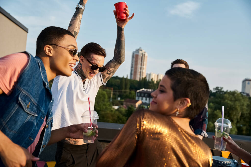 divertidos amigos com óculos de sol em roupas vivas bebendo coquetéis e se divertindo na festa - Foto, Imagem