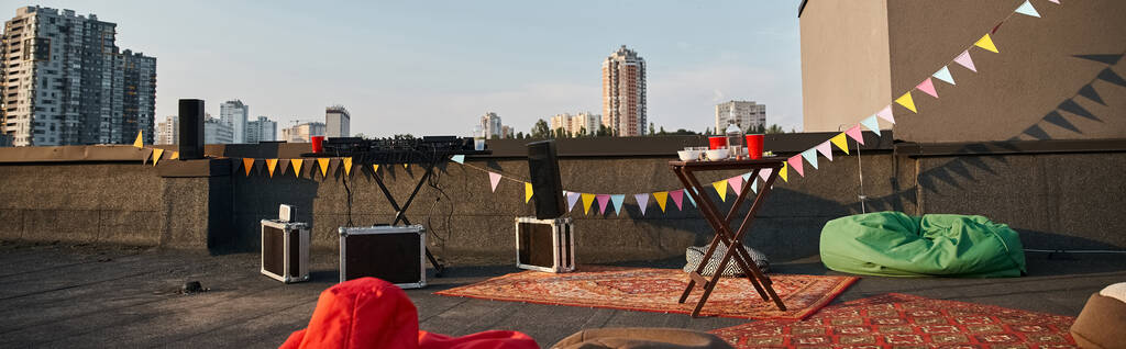 Çatı katının canlı halıları ve kırmızı bardaklı DJ ekipmanları ve afişi olan nesne fotoğrafı. - Fotoğraf, Görsel