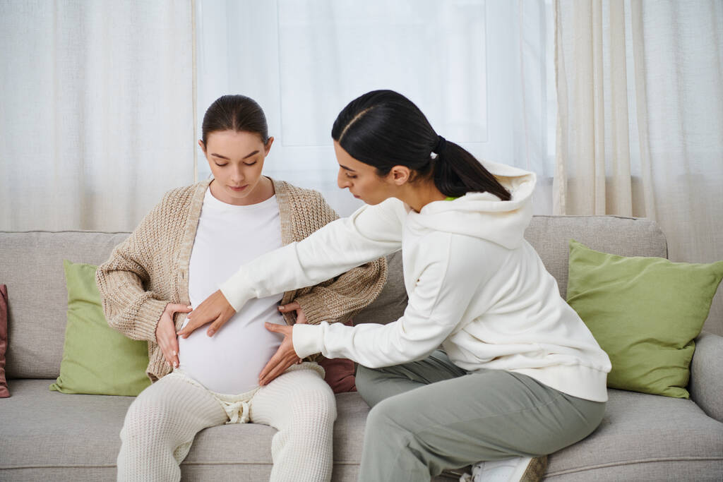 Egy terhes nő ül a kanapén az edzője mellett a szülői tanfolyamokon.. - Fotó, kép