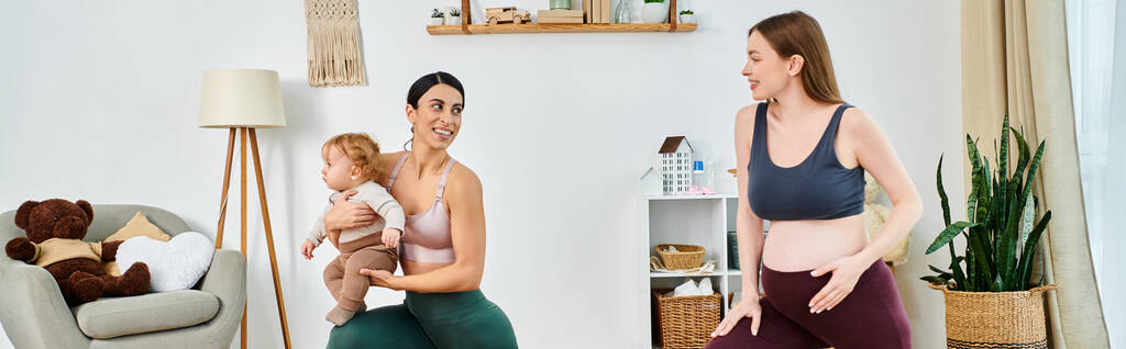 Una joven y hermosa madre sostiene a su bebé en una cálida sala de estar, guiada por su entrenador de los cursos de los padres. - Foto, Imagen
