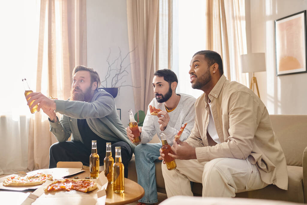 Trois beaux hommes interraciaux en tenue décontractée, s'amusant ensemble, assis autour d'une table et dégustant de la bière. - Photo, image