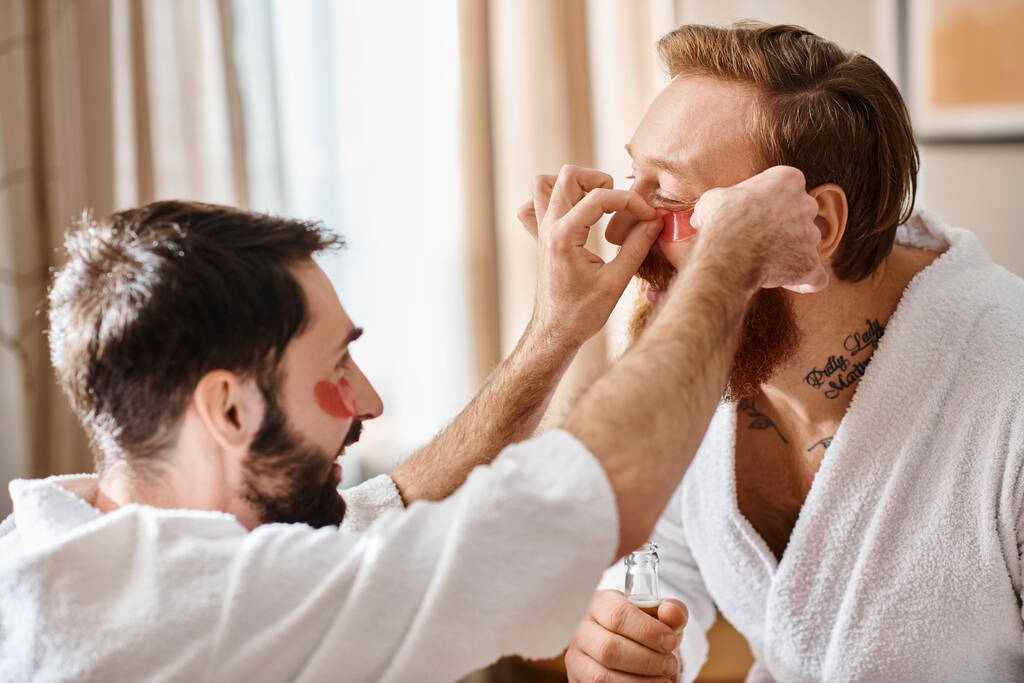 Kaksi miestä kylpytakissa auttavat iloisesti toisiaan laittamaan silmälappuja.. - Valokuva, kuva