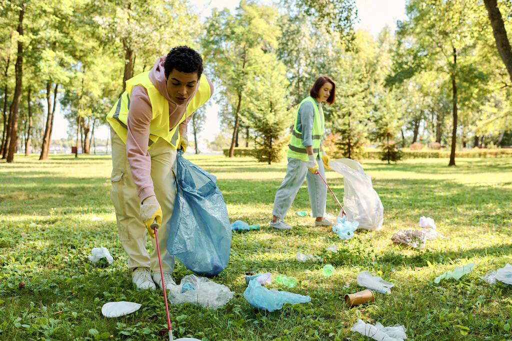 Diverse echtparen dragen veiligheidsvesten en handschoenen schoonmaak park, staan in weelderig groen gras met eenheid en liefde. - Foto, afbeelding