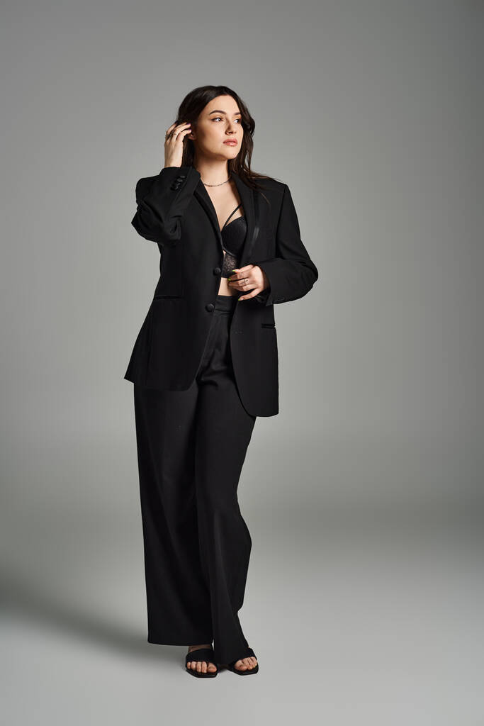 Una donna elegante plus-size in un abito nero conversare su un telefono cellulare, trasudando fiducia e raffinatezza. - Foto, immagini