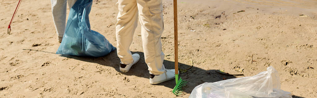 Wielorasowa ciężko pracująca para pasjonująco sprzątająca park w rękawiczkach ochronnych. - Zdjęcie, obraz
