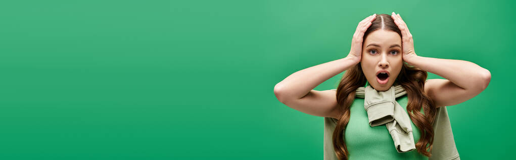 Жінка в 20 років прикриває вуха руками в студії, шукаючи відпочинок від шуму. - Фото, зображення