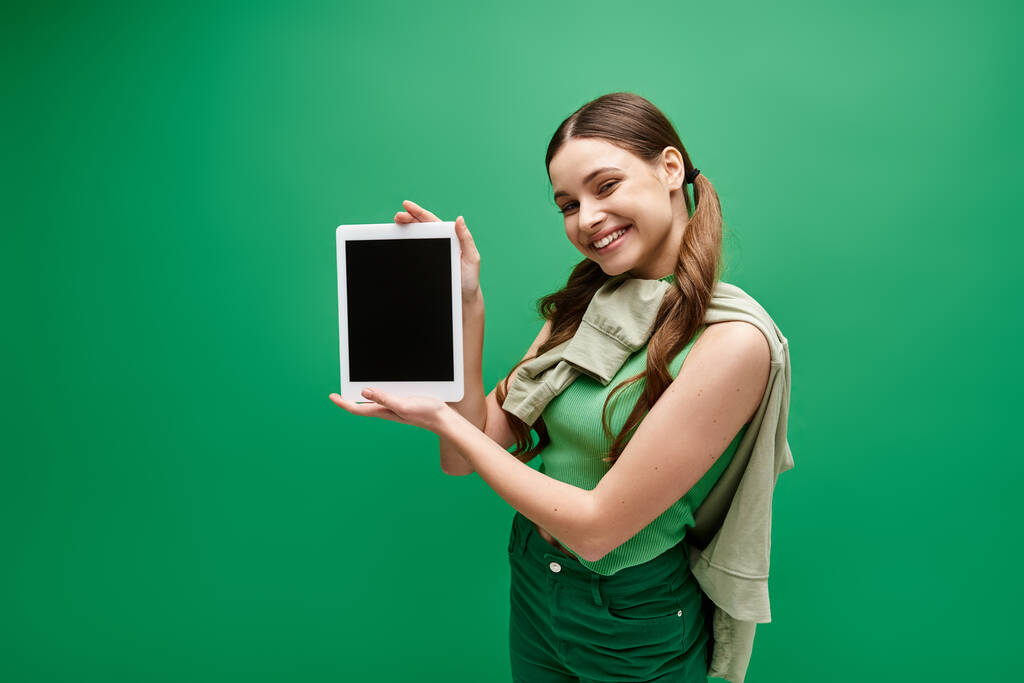 Uma jovem de 20 anos segurando um tablet em suas mãos, engajada com o mundo digital. - Foto, Imagem