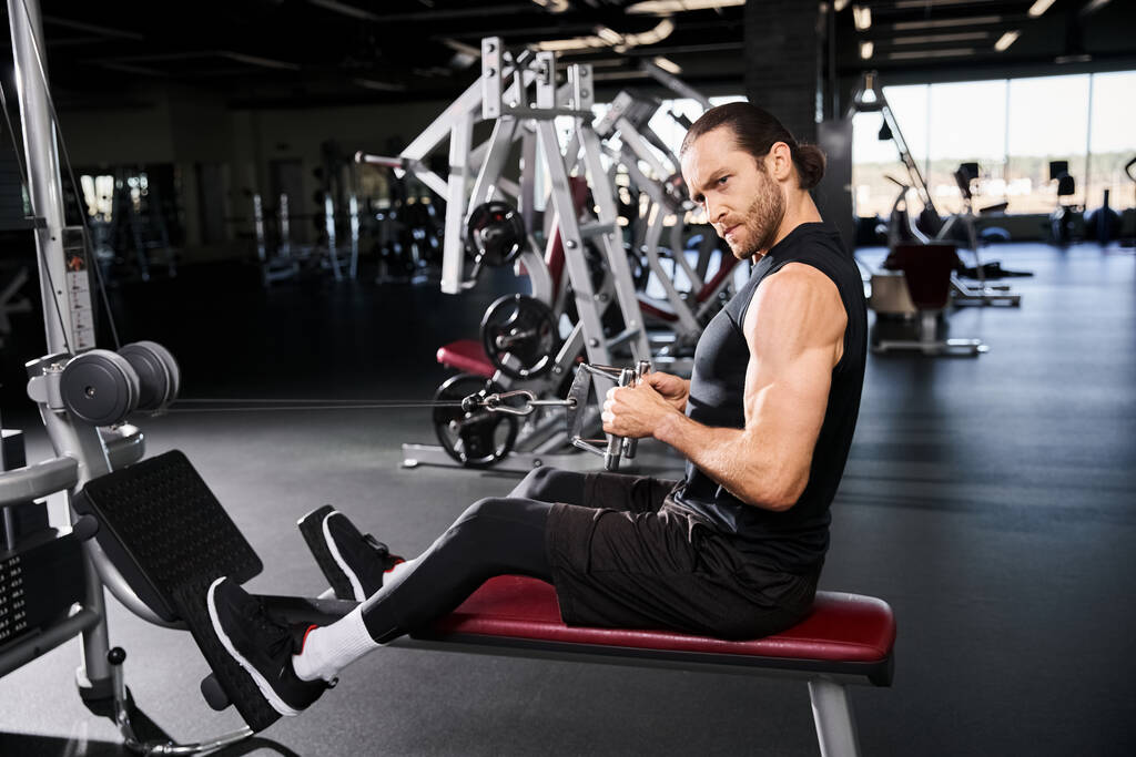 Ένας συγκεντρωμένος άντρας με στολή γυμναστικής κάθεται στοχαστικά σε ένα παγκάκι στο γυμναστήριο.. - Φωτογραφία, εικόνα
