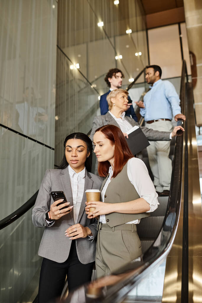 Разнообразная группа бизнесменов, стоящих на эскалаторе, двигающихся вверх. - Фото, изображение