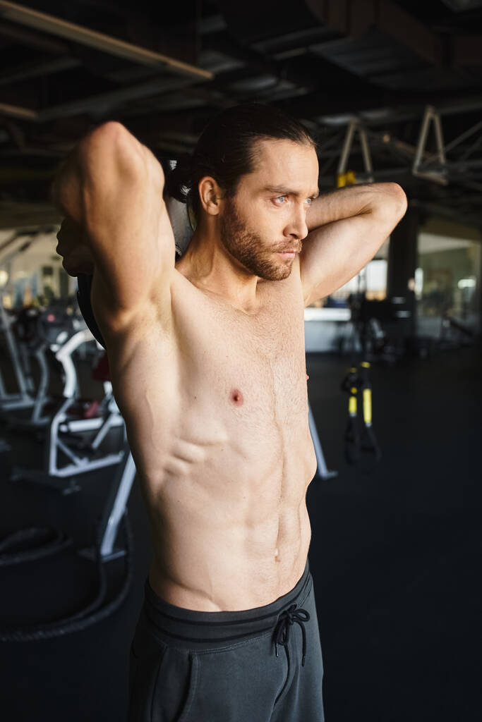 Ein hemdloser und muskulöser Sportler, der in einem Fitnessstudio trainiert. - Foto, Bild