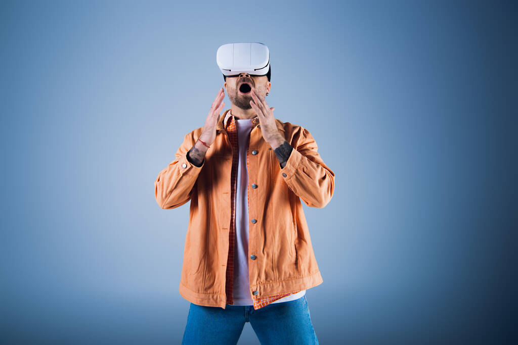 Ένας άνθρωπος σε μια εικονική πραγματικότητα headset εξερευνά την ψηφιακή σφαίρα, ενώ στέκεται μπροστά από ένα ζωντανό μπλε φόντο. - Φωτογραφία, εικόνα