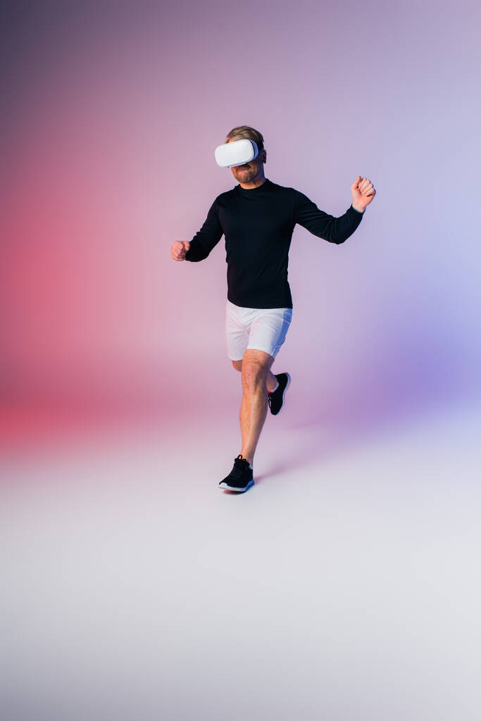 Ein Mann in schwarzem Hemd und weißer Hose sprintet zielstrebig in sein vr-Headset - Foto, Bild