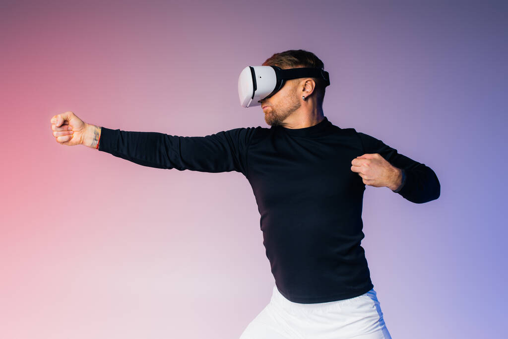 A man in a black shirt stands blindfolded, immersing himself in unknown realms through his virtual reality headset in a studio setting. - Photo, Image