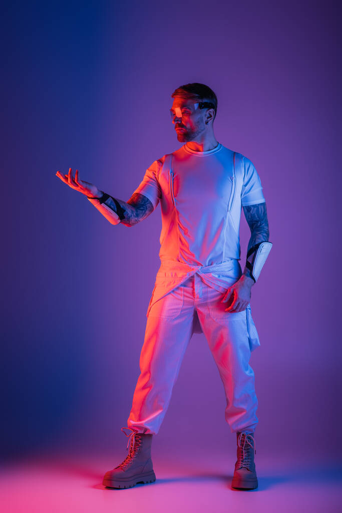 純粋な白いシャツとズボンで覆われた男は,バーチャルリアリティスタジオに自信を持って立っています, 優雅さを発する彼の存在. - 写真・画像