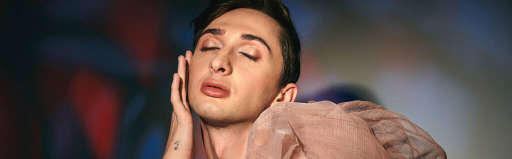 elegantní androgynní móda s tmavými vlasy v pastelové elegantní oblečení pózování se zavřenýma očima, banner - Fotografie, Obrázek