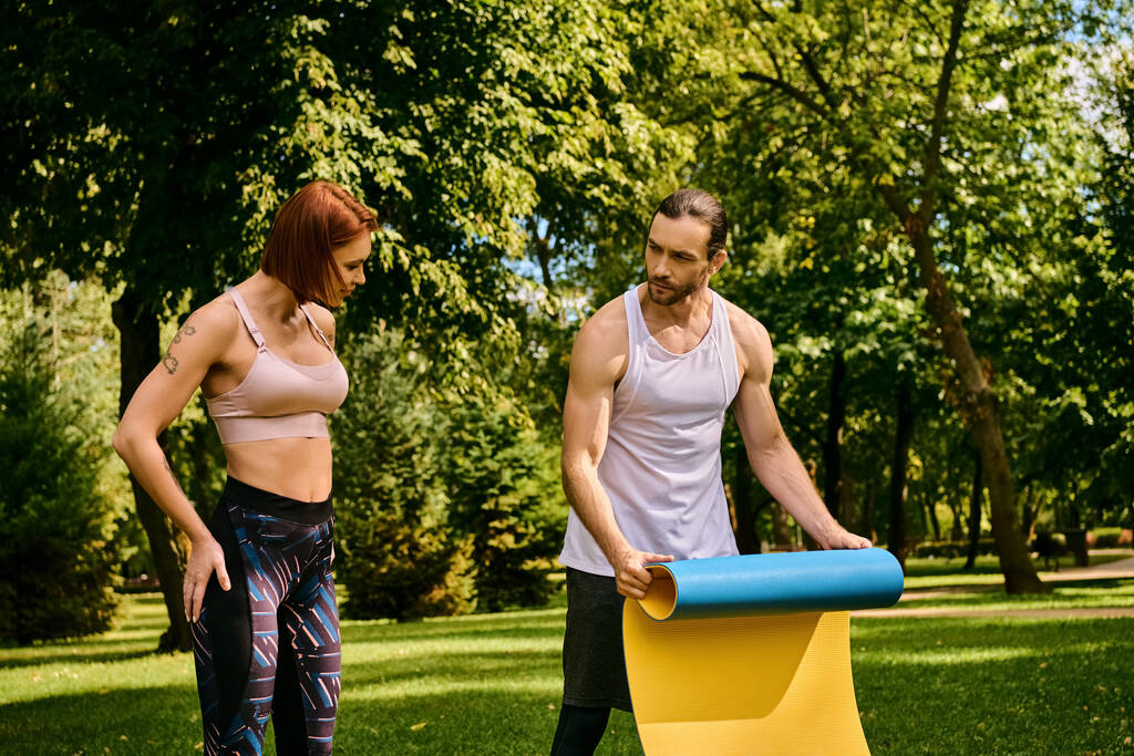 Une femme en tenue de sport, avec un entraîneur personnel faisant de l'exercice dans un parc, faisant preuve de détermination et de motivation. - Photo, image