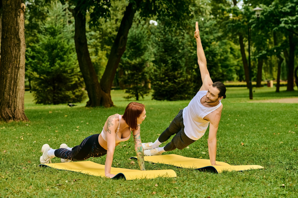 A man and woman in sportswear performing yoga poses in a serene park setting. - Photo, Image