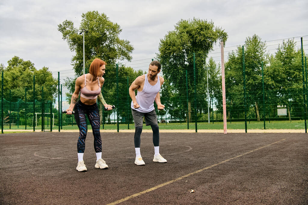 Spor giyimli iki atletik kadın bir tenis kortunun tepesinde güvenle duruyor, azim ve motivasyon gösteriyorlar.. - Fotoğraf, Görsel