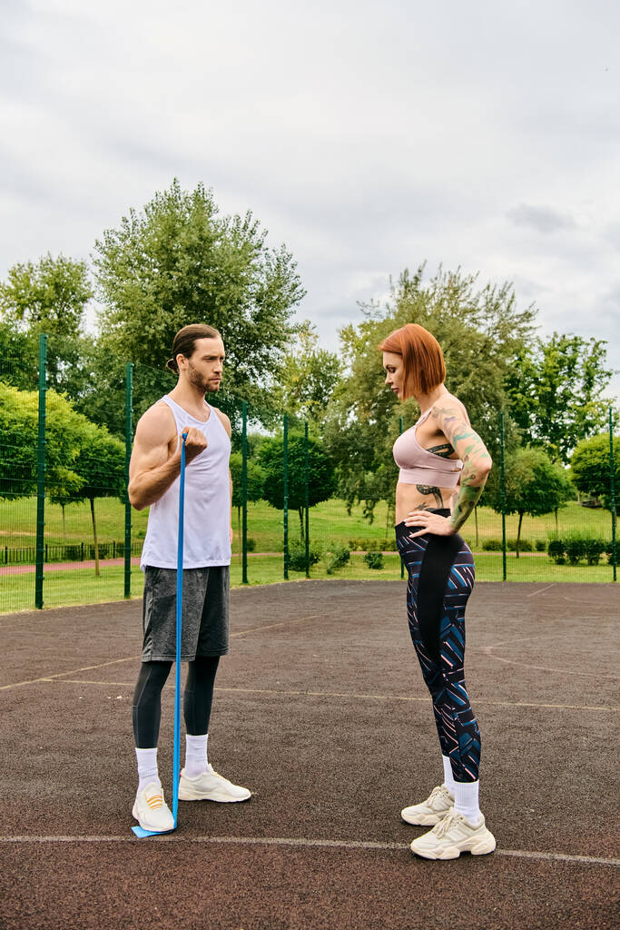 Определенный мужчина и женщина в спортивной одежде стоят на трибуне, готовые к сложной тренировке - Фото, изображение