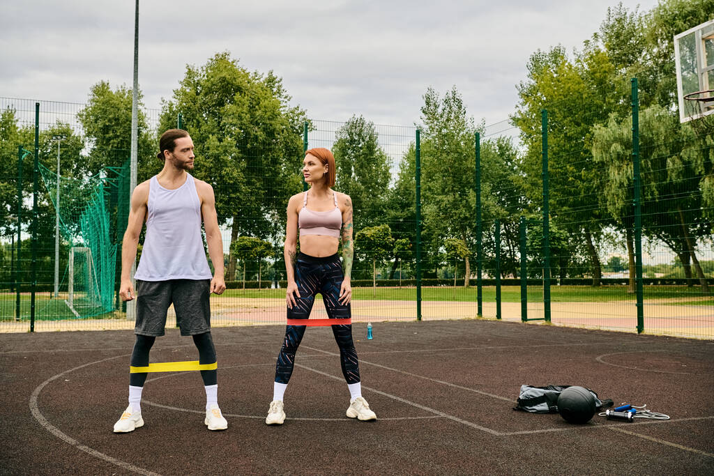 Een man en vrouw in sportkleding trainen op een veld met vastberadenheid en motivatie. - Foto, afbeelding
