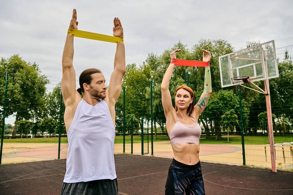 A man and woman in sportswear during resistance band training - Photo, Image