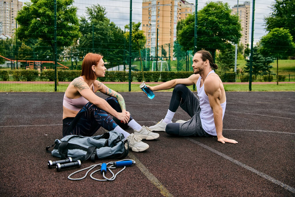 Ein Mann und eine Frau in Sportbekleidung trainieren gemeinsam auf einem Basketballfeld und zeigen Entschlossenheit und Motivation. - Foto, Bild