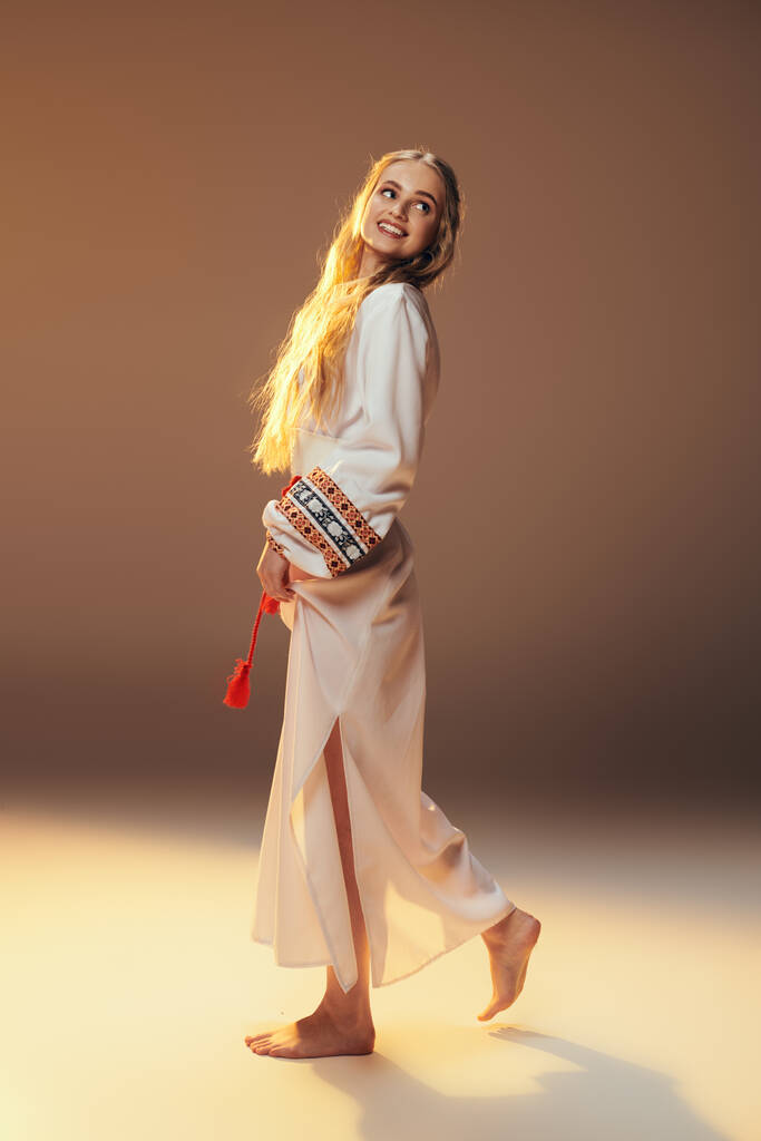 Mavka jovem em um vestido branco bate uma pose em um cenário de estúdio, incorporando elementos de fadas e fantasia. - Foto, Imagem