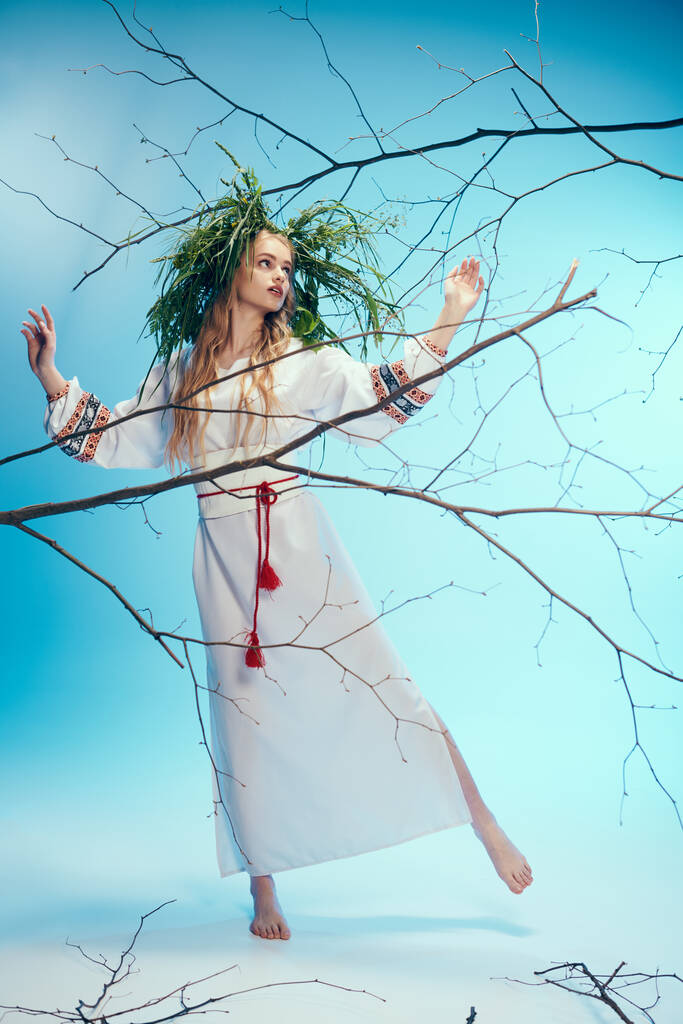 Eine junge Mavka in traditionellem Outfit mit Zweigen in einer zauberhaften Studiokulisse. - Foto, Bild