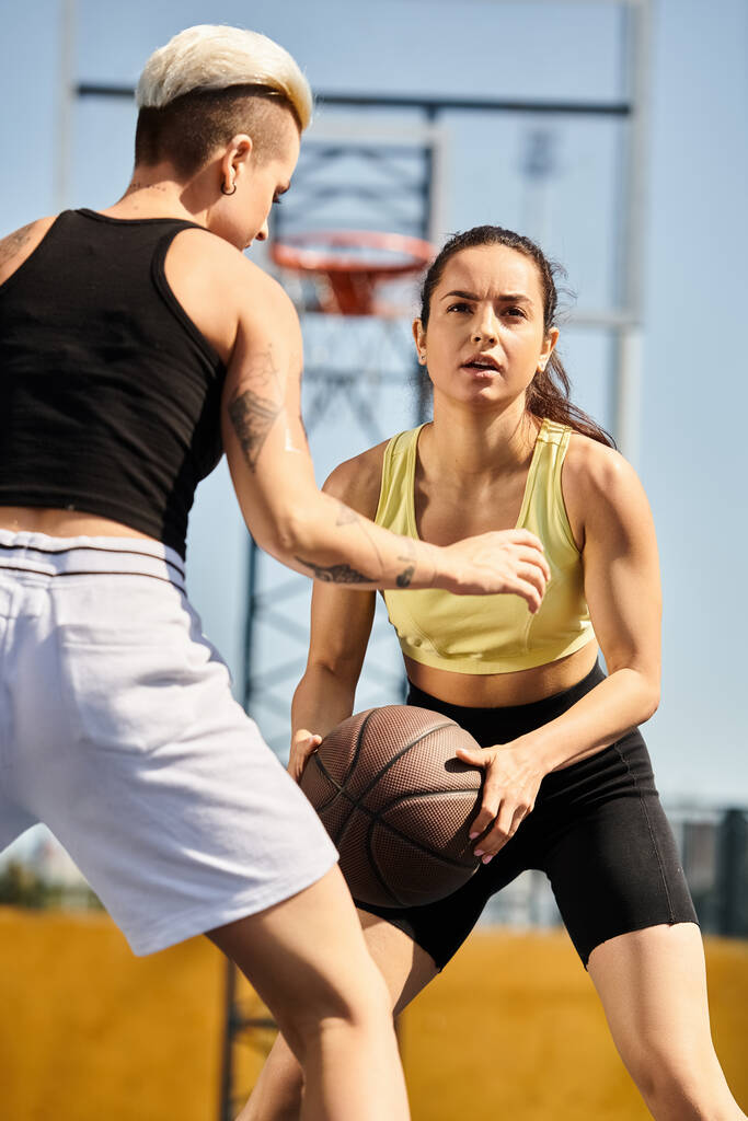 друзья энергично играют в баскетбол на открытой площадке, демонстрируют свой атлетизм и спортивное мастерство. - Фото, изображение