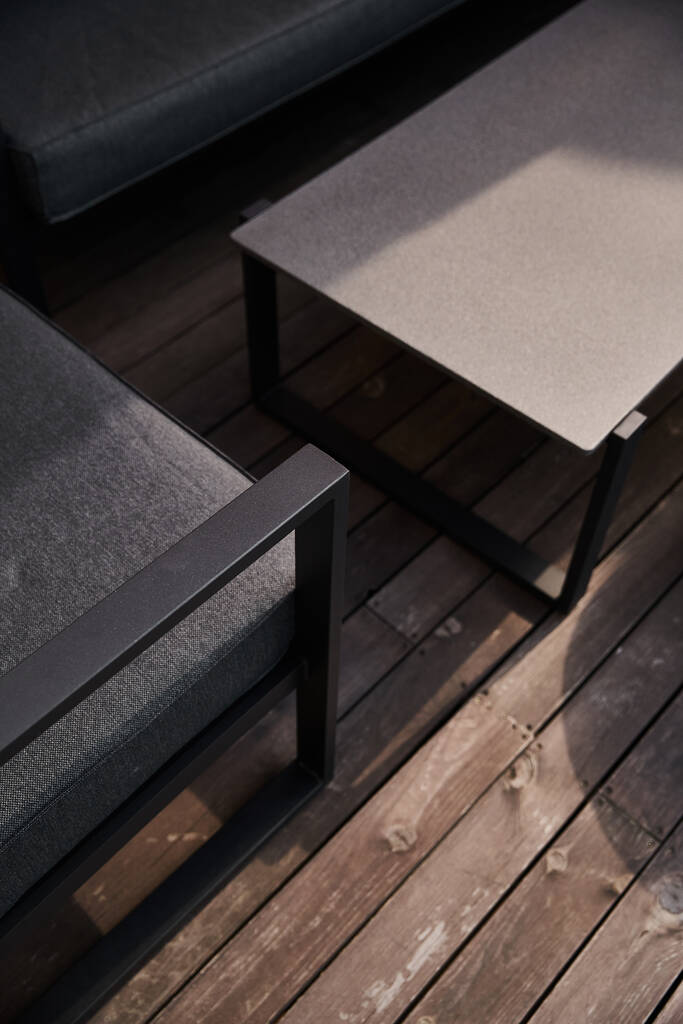 Una elegante mesa de centro descansa elegantemente sobre un suelo de madera rústico, creando una armoniosa mezcla de modernidad y encanto tradicional. - Foto, Imagen