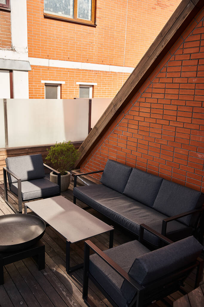 Rauhallinen patio koristeltu tyylikäs sohva, tyylikäs pöytä, ja kodikas tuolit, kutsuva rentoutumista ja nautintoa - Valokuva, kuva