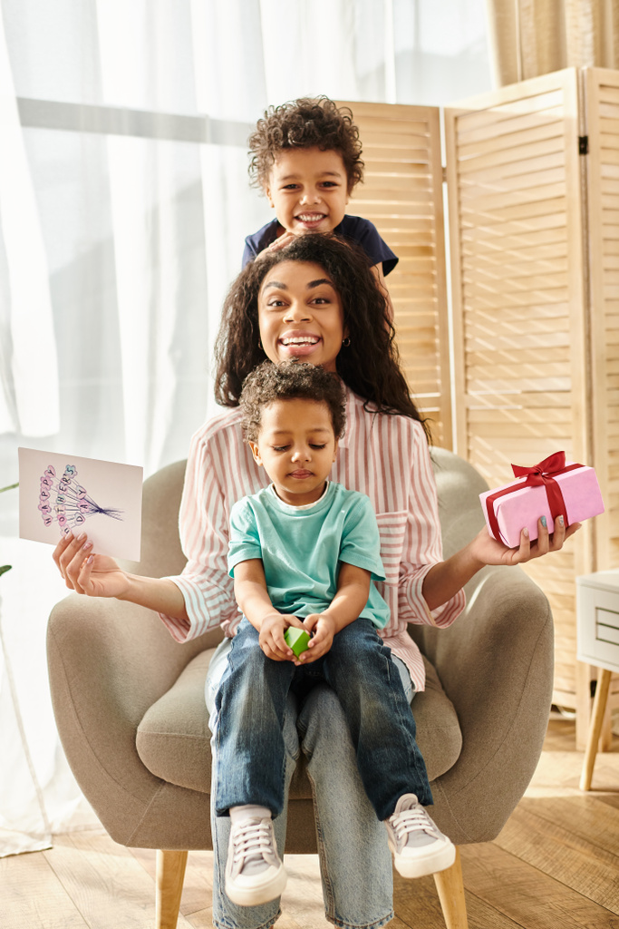 jolly afro-amerikai nő fiaival képeslapokkal és ajándék mosolygós kamera, Anyák napja - Fotó, kép