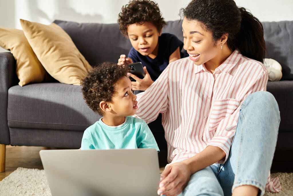 joyeuse jolie mère afro-américaine regardant ses deux fils avec amour en regardant des films - Photo, image