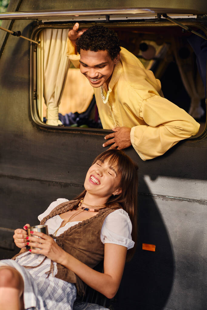 Interraciaal paar geniet van een romantische reis op de rug van een busje, omgeven door natuur schoonheid. - Foto, afbeelding