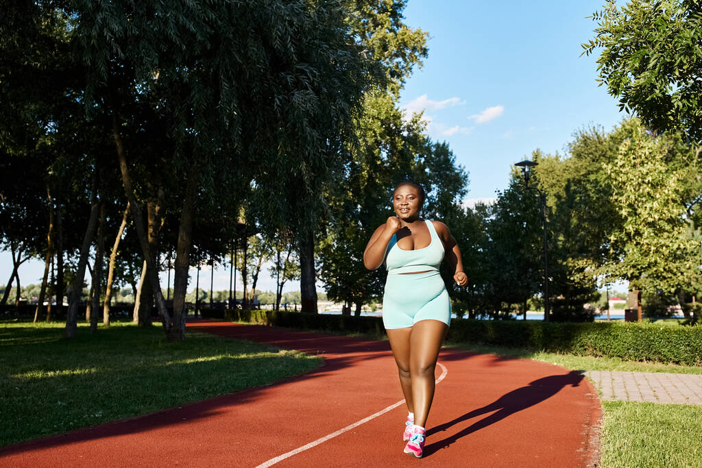 Μια καμπυλωτή Αφρο-Αμερικανίδα γυναίκα με αθλητικά να τρέχει σε μια ζωντανή κόκκινη γραμμή.. - Φωτογραφία, εικόνα